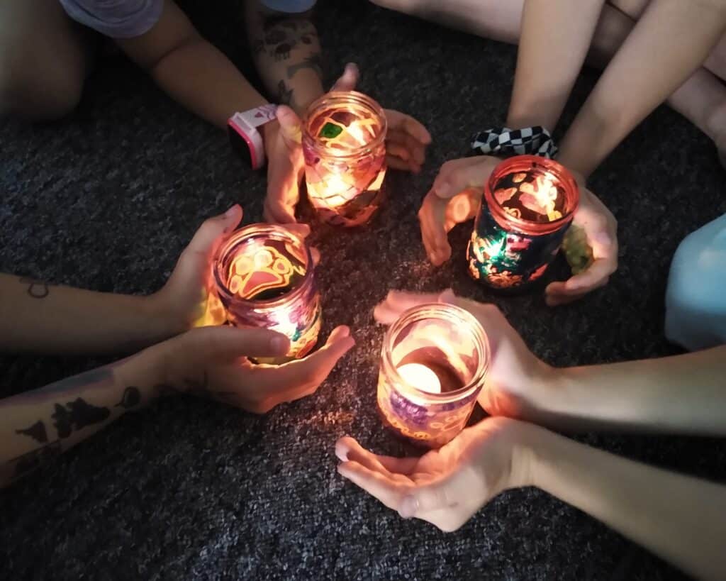 Dzieci trzymające w rękach własnoręcznie wykonane witraże ze słoików